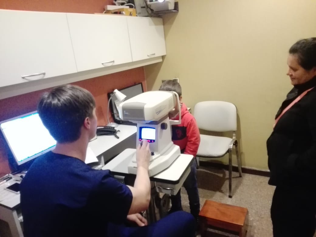 Médico examina a una niña con equipo oftalmológico